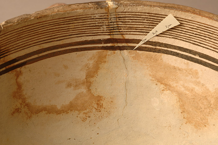 Before the establishment of a modern conservation lab, museum workers and restorers applied substances that interacted badly with original materials. Here, materials used to fill losses in the bowl have leached into the clay body of the pot, causing staining.